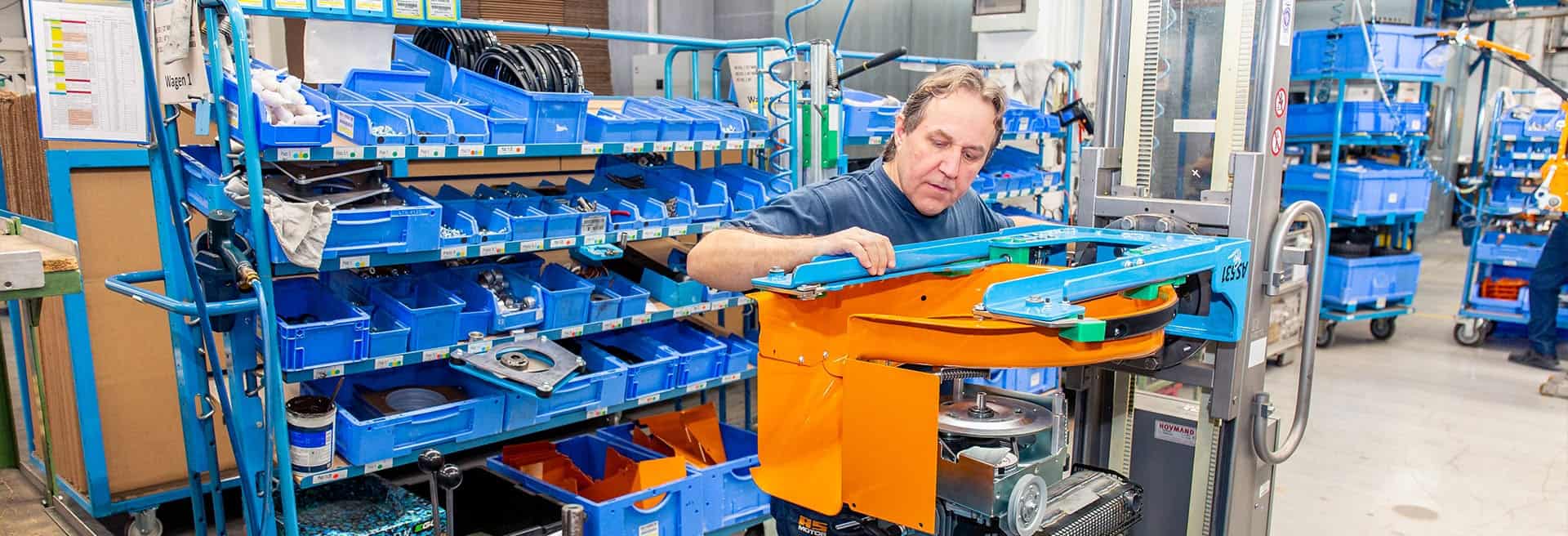 AS-Motor warranty highlight, showcasing the craftsmanship inside the AS-Motor factory. A man is torquing down the main bolt for the mower blade